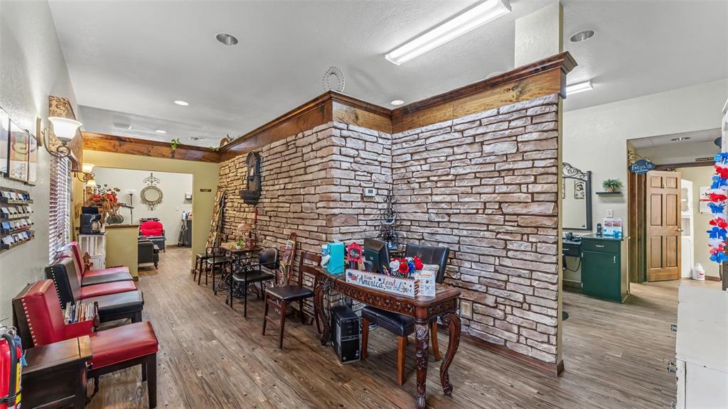 A waiting area features red chairs, a stone accent wall, and wood-look flooring — 565 W MAIN STREET, BARTOW, FL