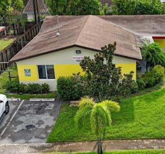 An exterior view of a one-story building with yellow and beige walls and a brown roof — 1500 NW 58th Terrace, Sunrise FL 33313, SUNRISE, FL