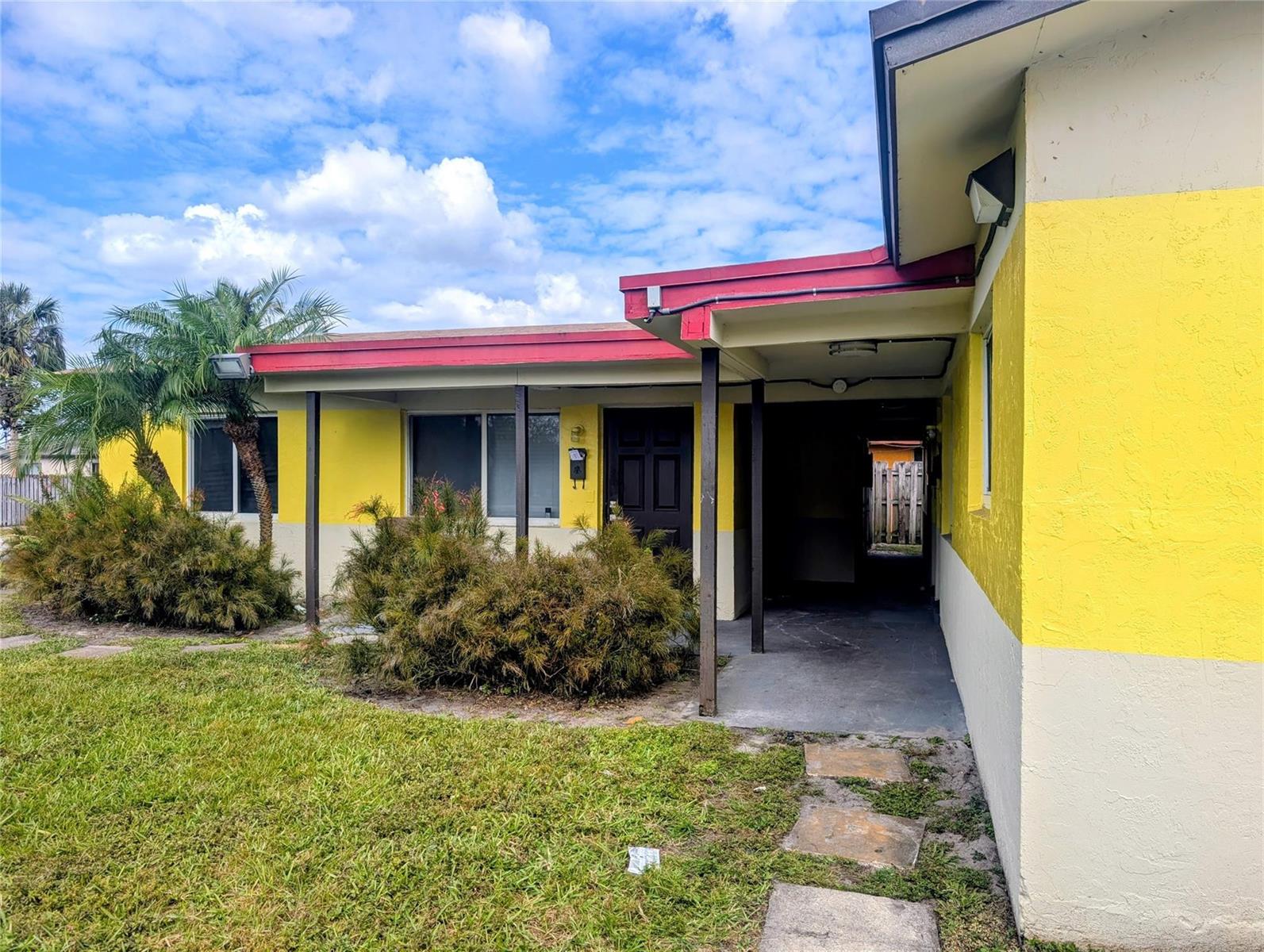 A yellow and white house exterior features a covered entryway and a small palm tree — 1500 NW 58th Terrace, Sunrise FL 33313, SUNRISE, FL