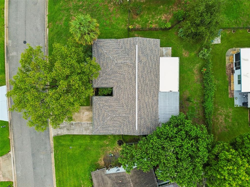 An aerial view shows a house with a shingled roof, a driveway, and surrounding trees — 12807 WILLOWDALE WAY, HUDSON, FL