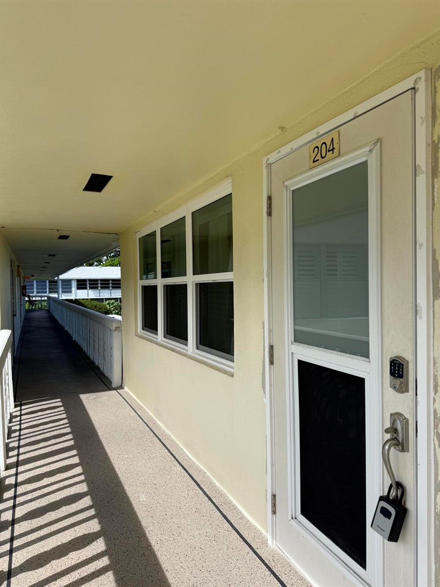An exterior walkway leads to the entrance of unit 204 with a keypad lock — 204 Durham D # 204, Deerfield Beach FL 33442, DEERFIELD BEACH, FL