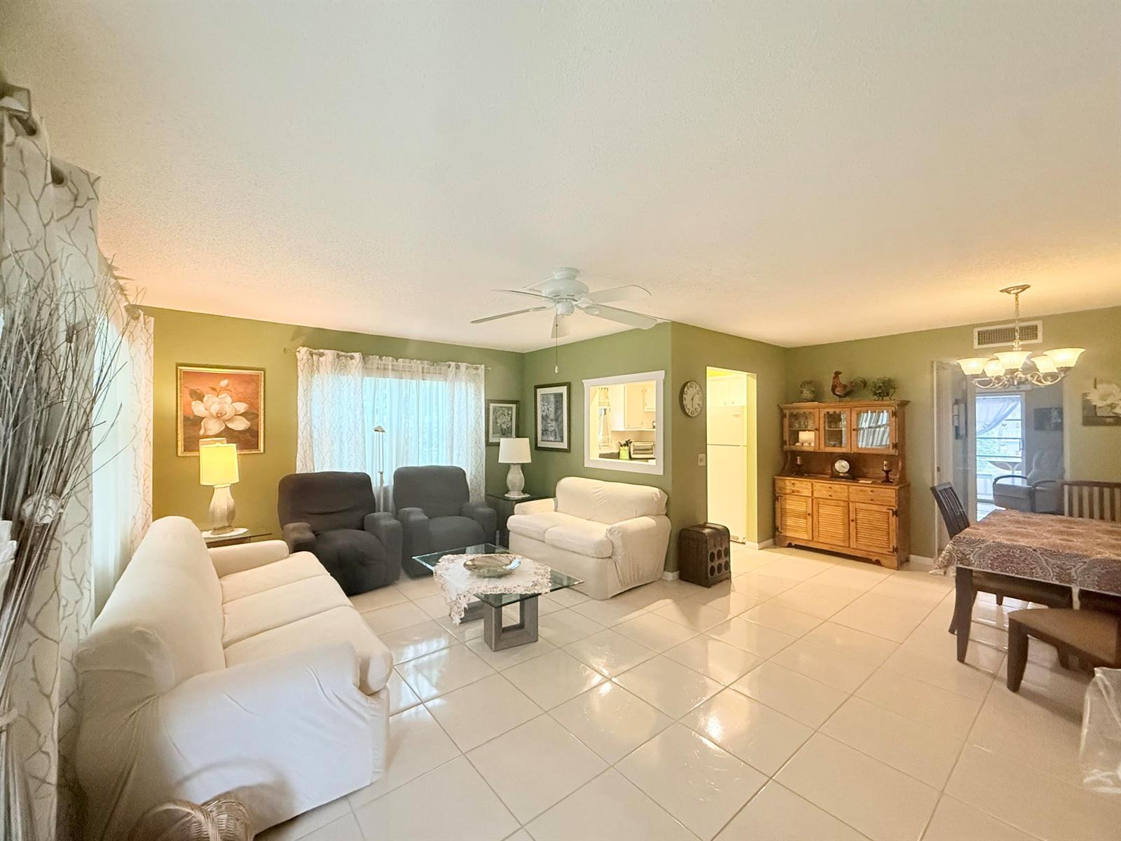 A living and dining area with sage green walls, white tile floors, and white furniture — 204 Durham D # 204, Deerfield Beach FL 33442, DEERFIELD BEACH, FL
