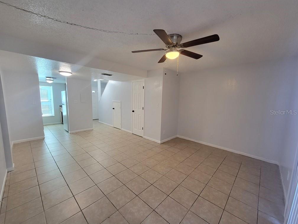 An open-concept living area features light-colored tile flooring, a ceiling fan, and white walls — 5122 TEMPLE HEIGHTS ROAD UNIT D, TAMPA, FL