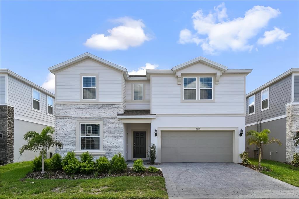 A two-story house with white siding, stone veneer, and a two-car garage — 4157 LANA AVENUE, DAVENPORT, FL