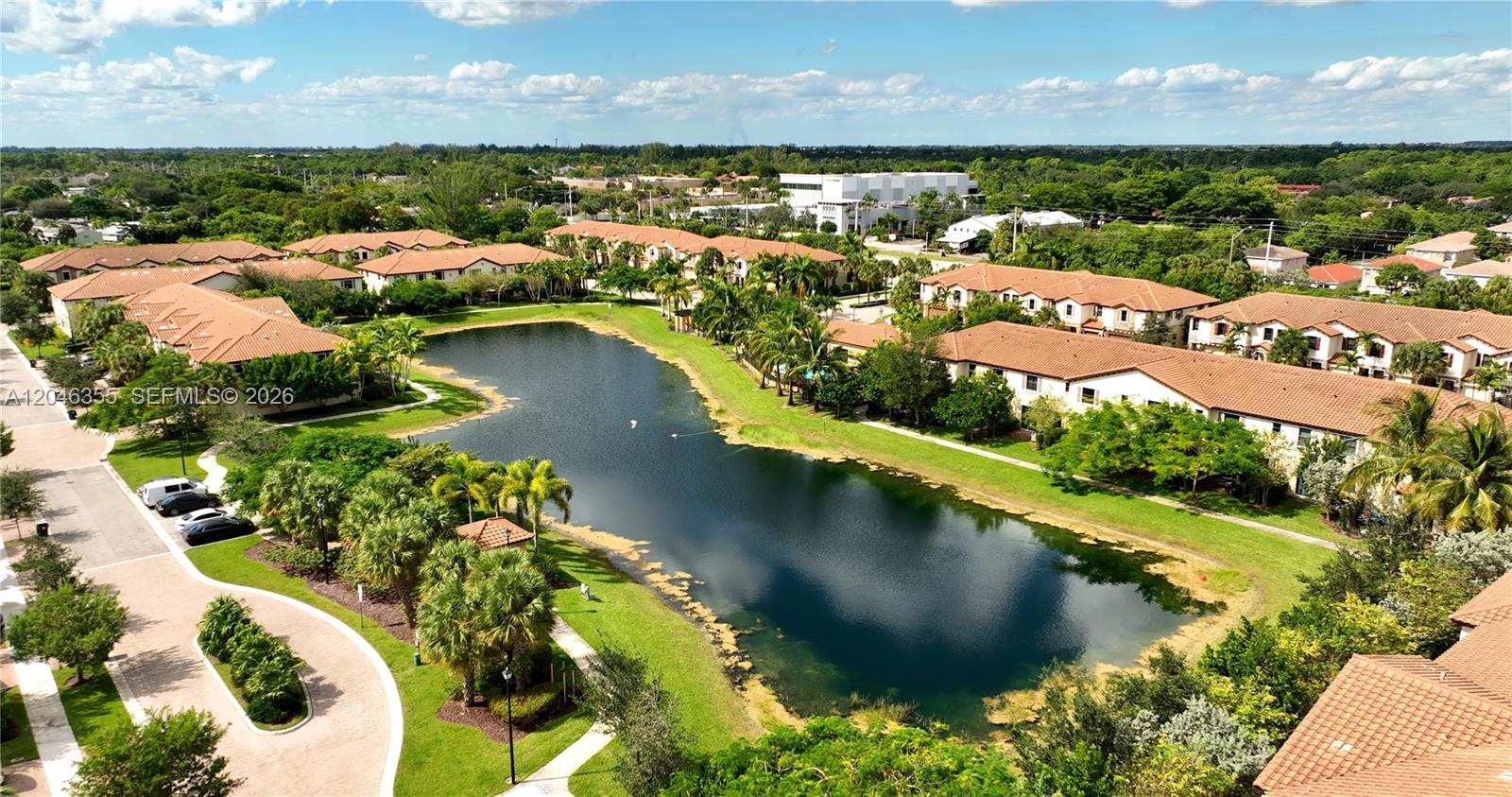 An aerial view shows a residential complex with multiple buildings surrounding a central pond — 3962 Devenshire Ct, Coconut Creek FL 33073, COCONUT CREEK, FL