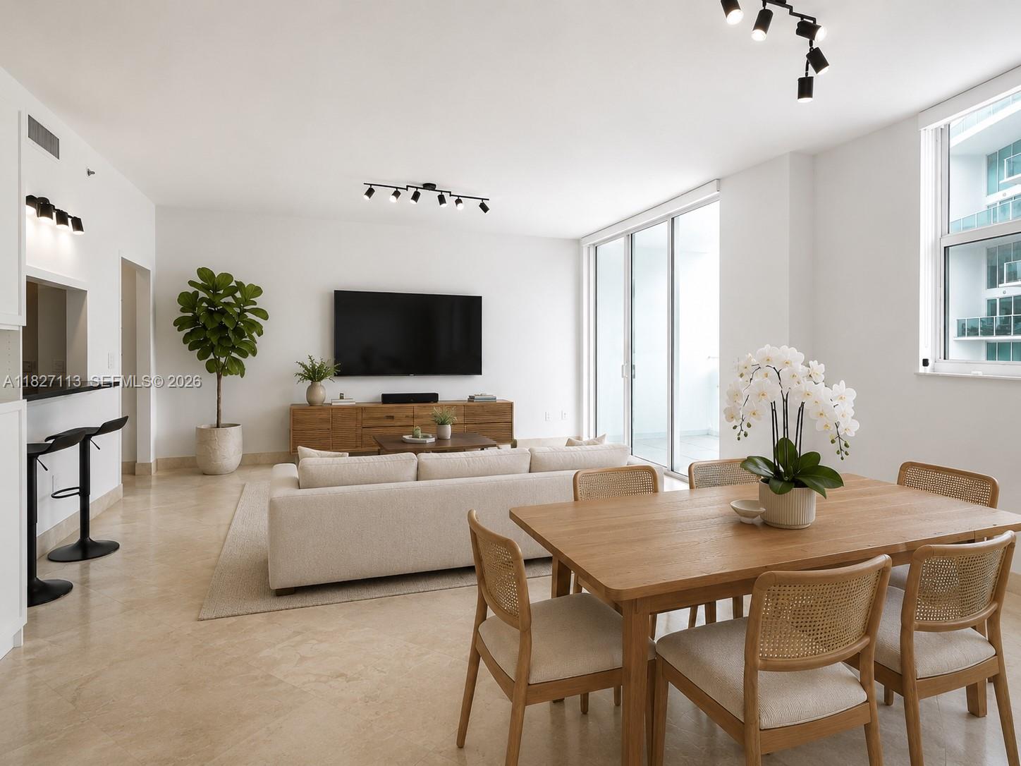 A modern living and dining room features light tile floors, white walls, and rattan chairs — 31 SE 5th St # 4021, Miami FL 33131, MIAMI, FL