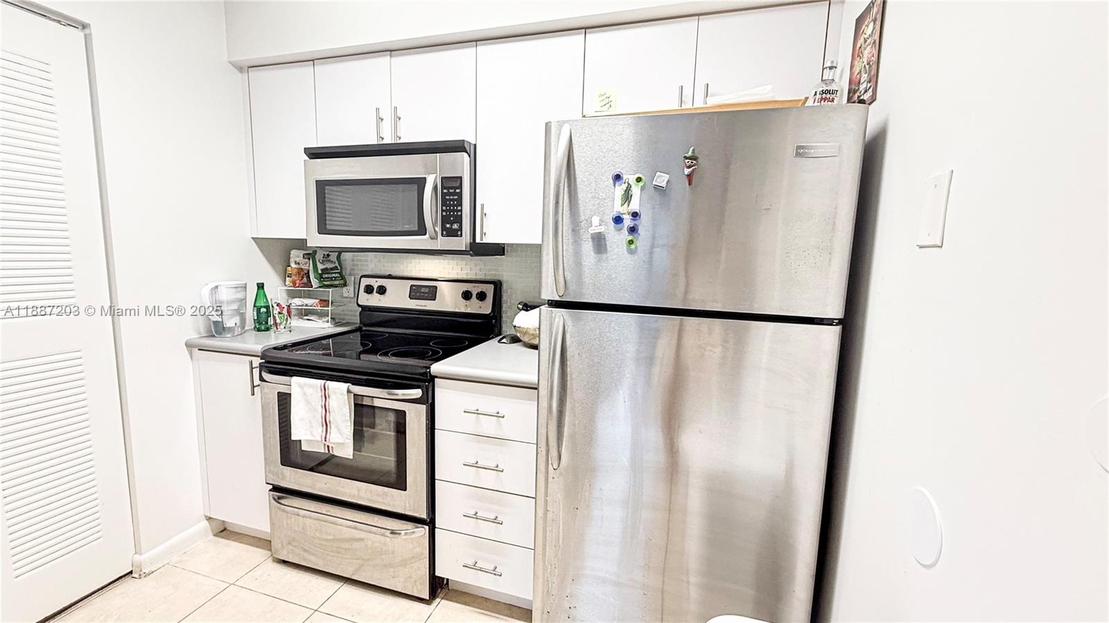 A kitchen features white cabinetry, stainless steel appliances, and light-colored tile flooring — 540 S Park Rd # 9, Hollywood FL 33021, HOLLYWOOD, FL