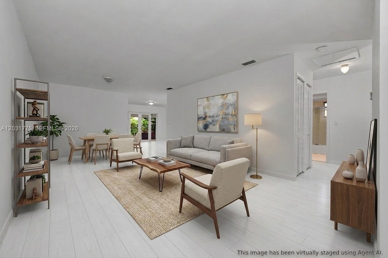 This virtually staged living and dining area features white flooring and neutral modern furniture — 23 NW 109th Ave, Miami FL 33172, MIAMI, FL