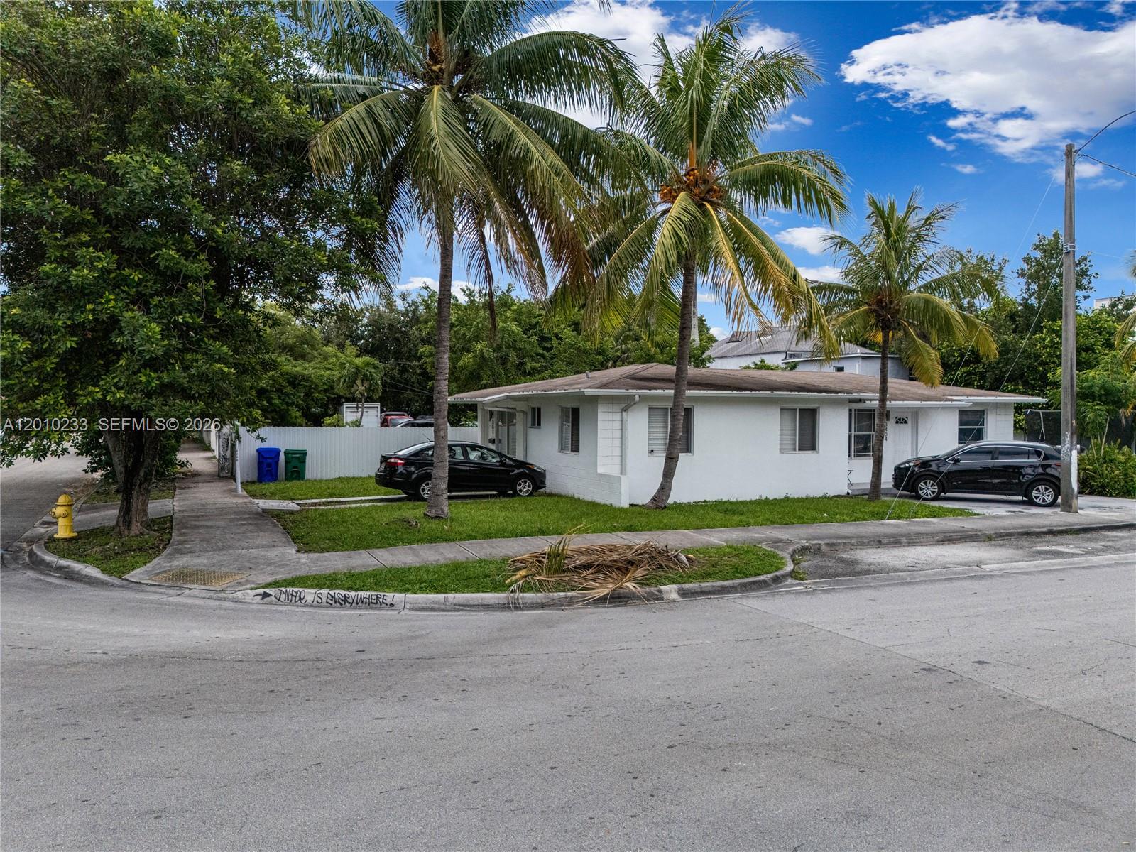 A white single-story house with two palm trees stands on a corner lot — 301 NW 34th St, Miami FL 33127, MIAMI, FL