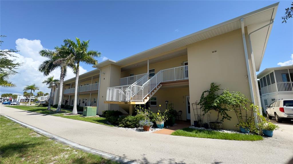 A two-story apartment building with a white metal staircase and a paved driveway — 3136 HARBOR BOULEVARD UNIT 2A, PORT CHARLOTTE, FL