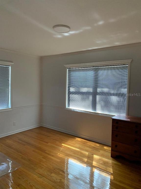A bedroom with hardwood floors, light-colored walls, and two windows with blinds — 362 FOSTER LANE, BELLEAIR, FL