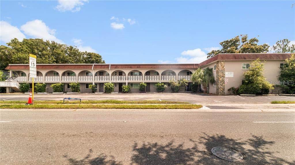 A two-story apartment building with arched balconies and a parking lot in the foreground — 5900 22ND AVENUE N, ST PETERSBURG, FL