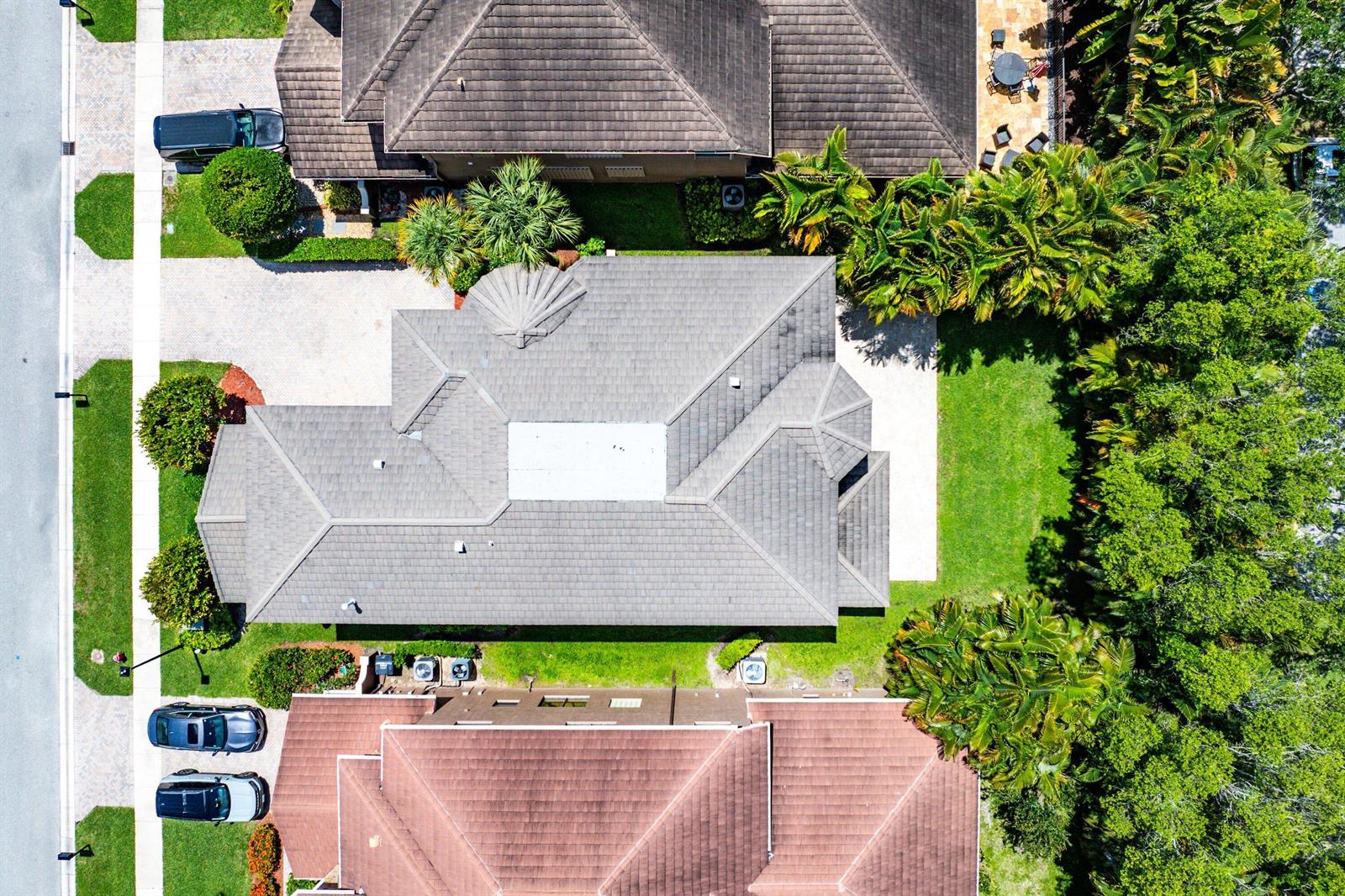 An aerial view shows a house with a gray tile roof and a backyard pool — 10293 Medicis Place, Wellington FL 33449, WELLINGTON, FL