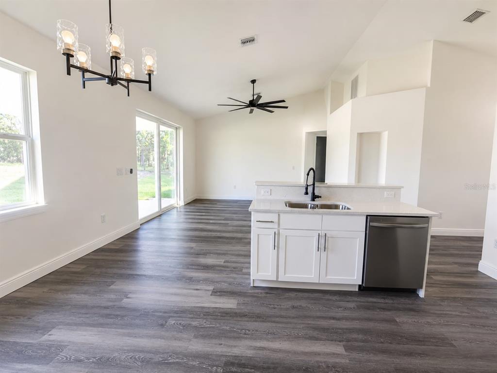 A kitchen island with a sink and dishwasher sits in an open-concept living area — 9483 SW 121ST TERRACE, DUNNELLON, FL