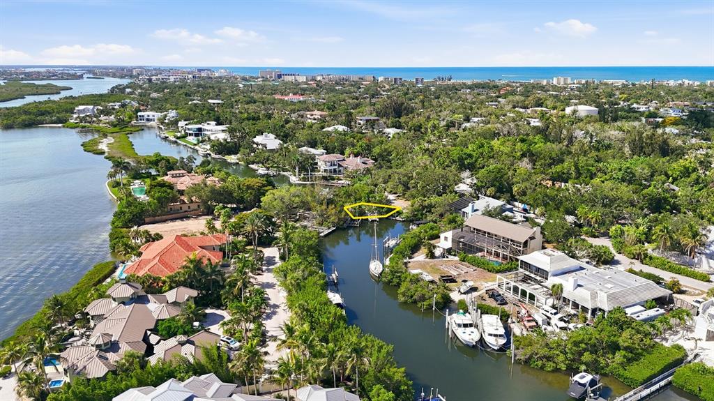 An aerial view shows a waterfront property with a boat dock and surrounding vegetation — 1325 HIDDEN HARBOR WAY, SARASOTA, FL