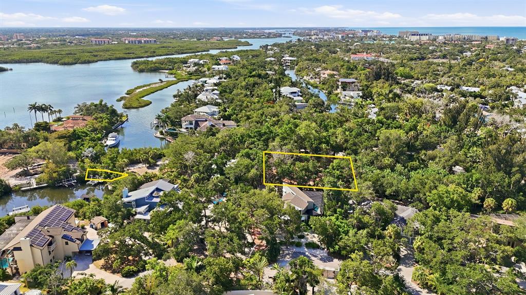 An aerial view shows a wooded residential area with two yellow-outlined plots of land — 1325 HIDDEN HARBOR WAY, SARASOTA, FL