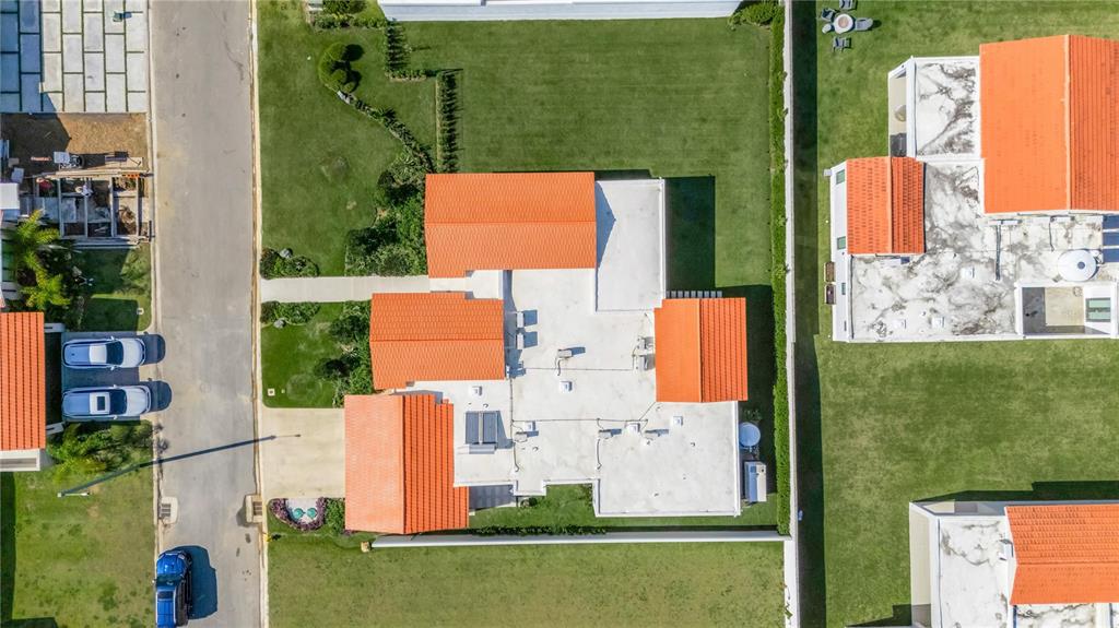 An aerial view shows a house with orange tiled roofs, a flat roof, and green lawns — 765 CAMINO DE LOS ANTURIOS, DORADO, PR