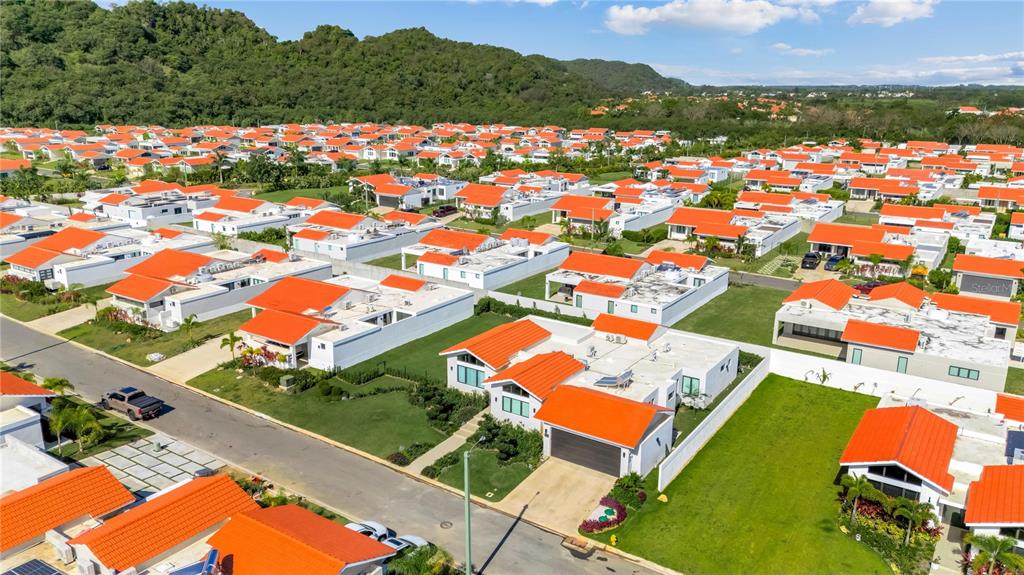 An aerial view shows a suburban neighborhood of white houses with orange roofs — 765 CAMINO DE LOS ANTURIOS, DORADO, PR