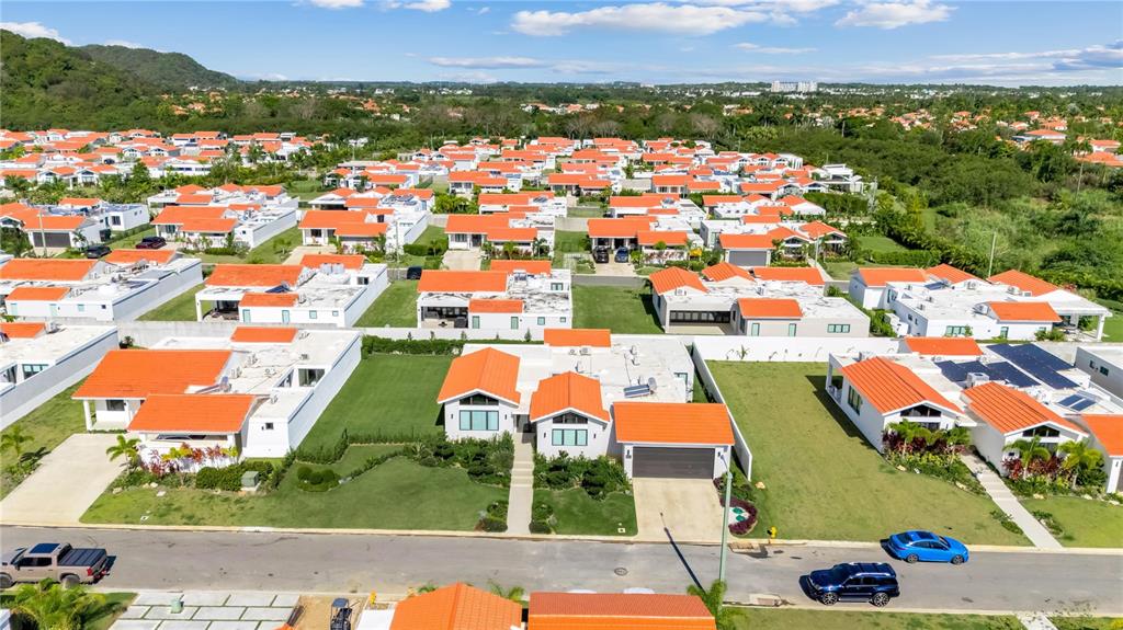 An aerial view shows a suburban neighborhood of white houses with orange tiled roofs — 765 CAMINO DE LOS ANTURIOS, DORADO, PR