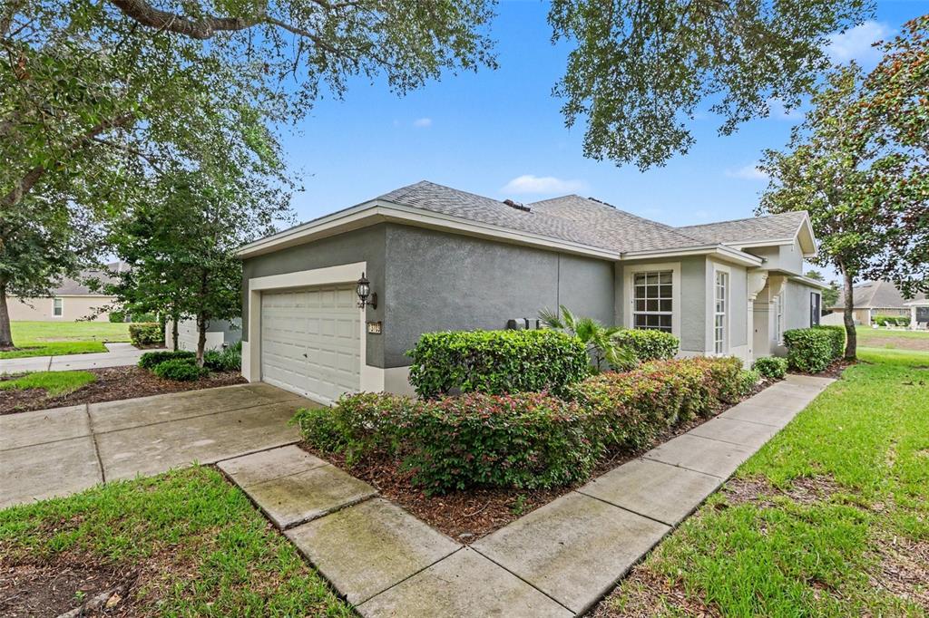 A gray stucco house with a one-car garage and a landscaped front yard — 13703 CREST LAKE DRIVE, HUDSON, FL