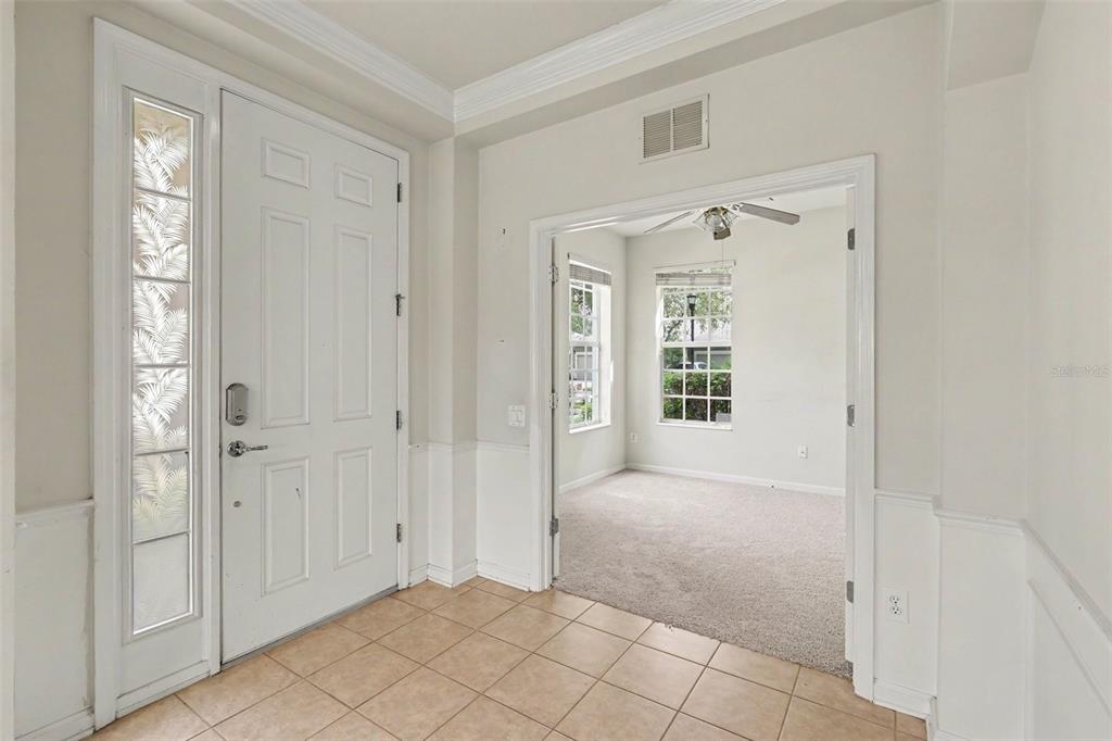 An entryway with tile flooring leads to a carpeted room through a wide doorway — 13703 CREST LAKE DRIVE, HUDSON, FL
