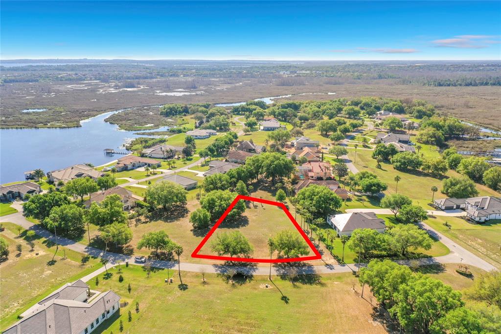 An aerial view shows a vacant residential lot outlined in red within a suburban neighborhood — MARIGOLD STREET, GROVELAND, FL