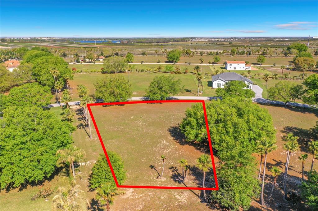 An aerial view shows a vacant, grassy lot outlined in red within a rural landscape — MARIGOLD STREET, GROVELAND, FL