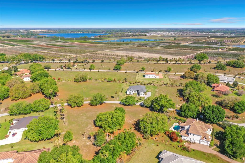 An aerial view shows several houses surrounded by large green lawns and agricultural fields — MARIGOLD STREET, GROVELAND, FL