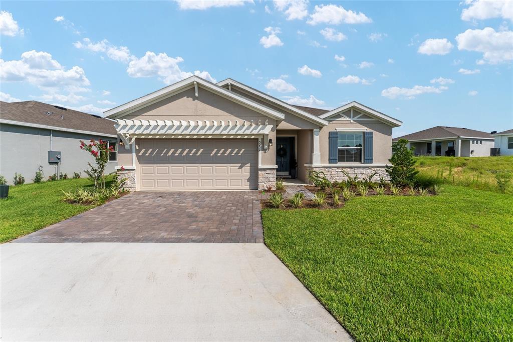 A single-story house features a paved driveway, a two-car garage, and stone veneer accents — 5254 NW 43RD LANE ROAD, OCALA, FL