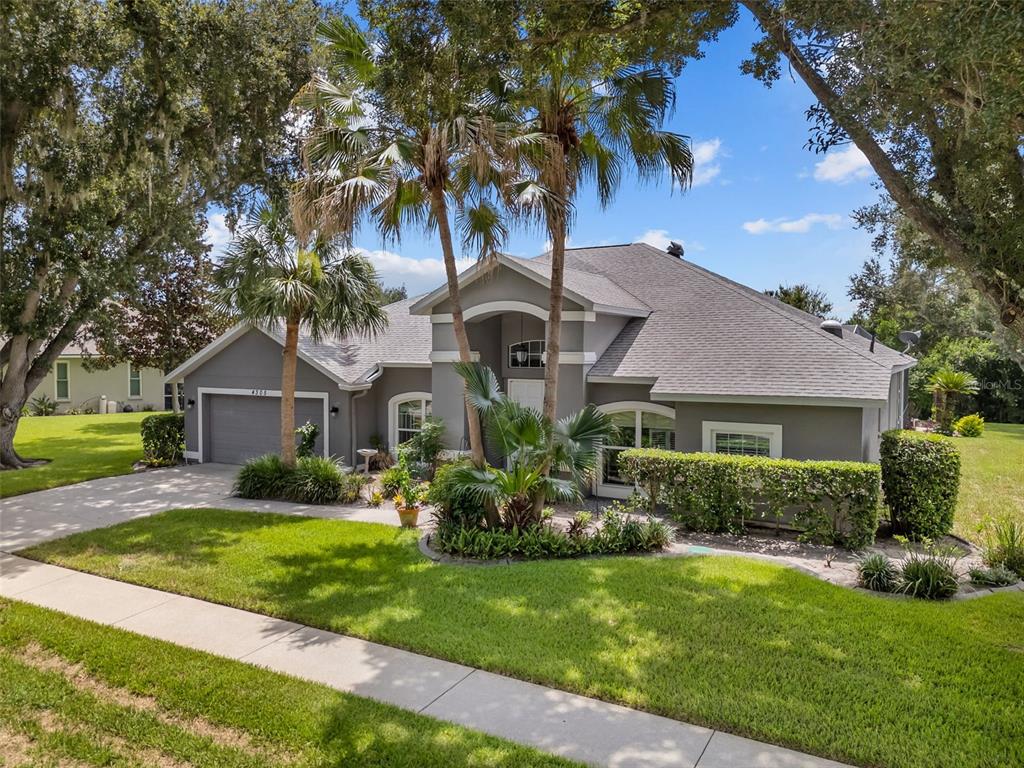 A single-story gray house with a two-car garage and palm trees in the front yard — 4305 GENTRICE DRIVE, VALRICO, FL