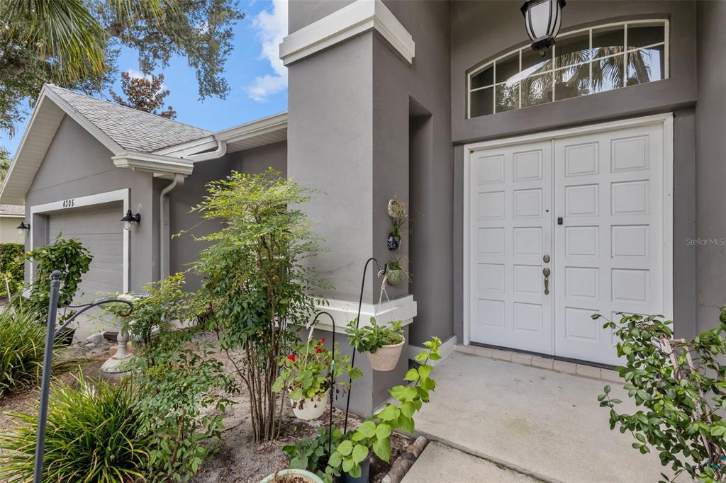 The exterior of a gray house features a double front door and a garage — 4305 GENTRICE DRIVE, VALRICO, FL