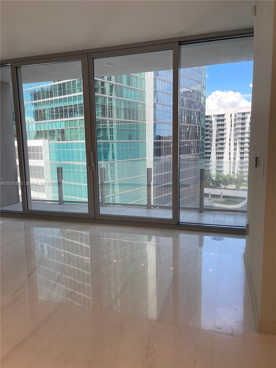 A room with polished white marble floors features floor-to-ceiling windows overlooking urban high-rise buildings — 300 Biscayne Blvd Way # 2008, Miami FL 33131, MIAMI, FL
