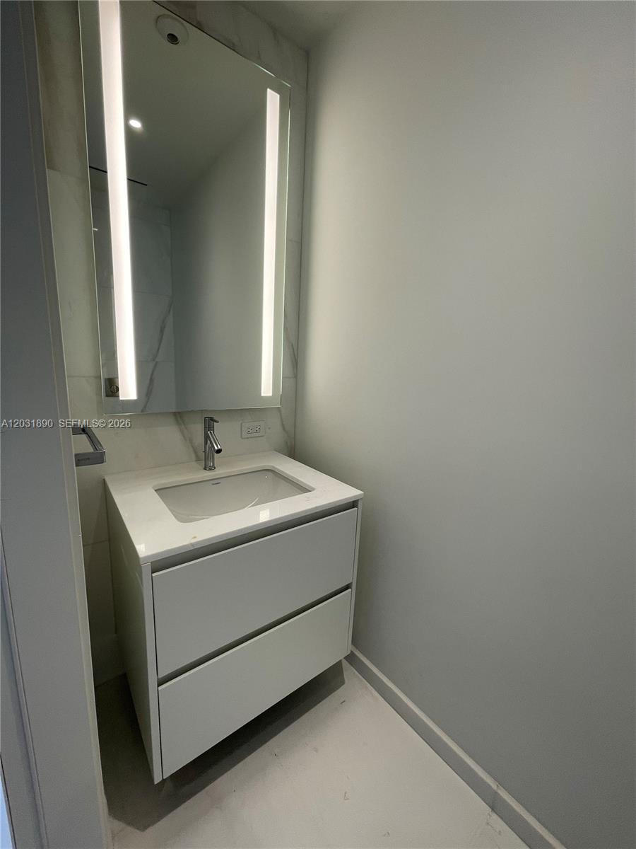 A modern bathroom features a white vanity, a rectangular sink, and an illuminated mirror — 300 Biscayne Blvd Way # 2008, Miami FL 33131, MIAMI, FL