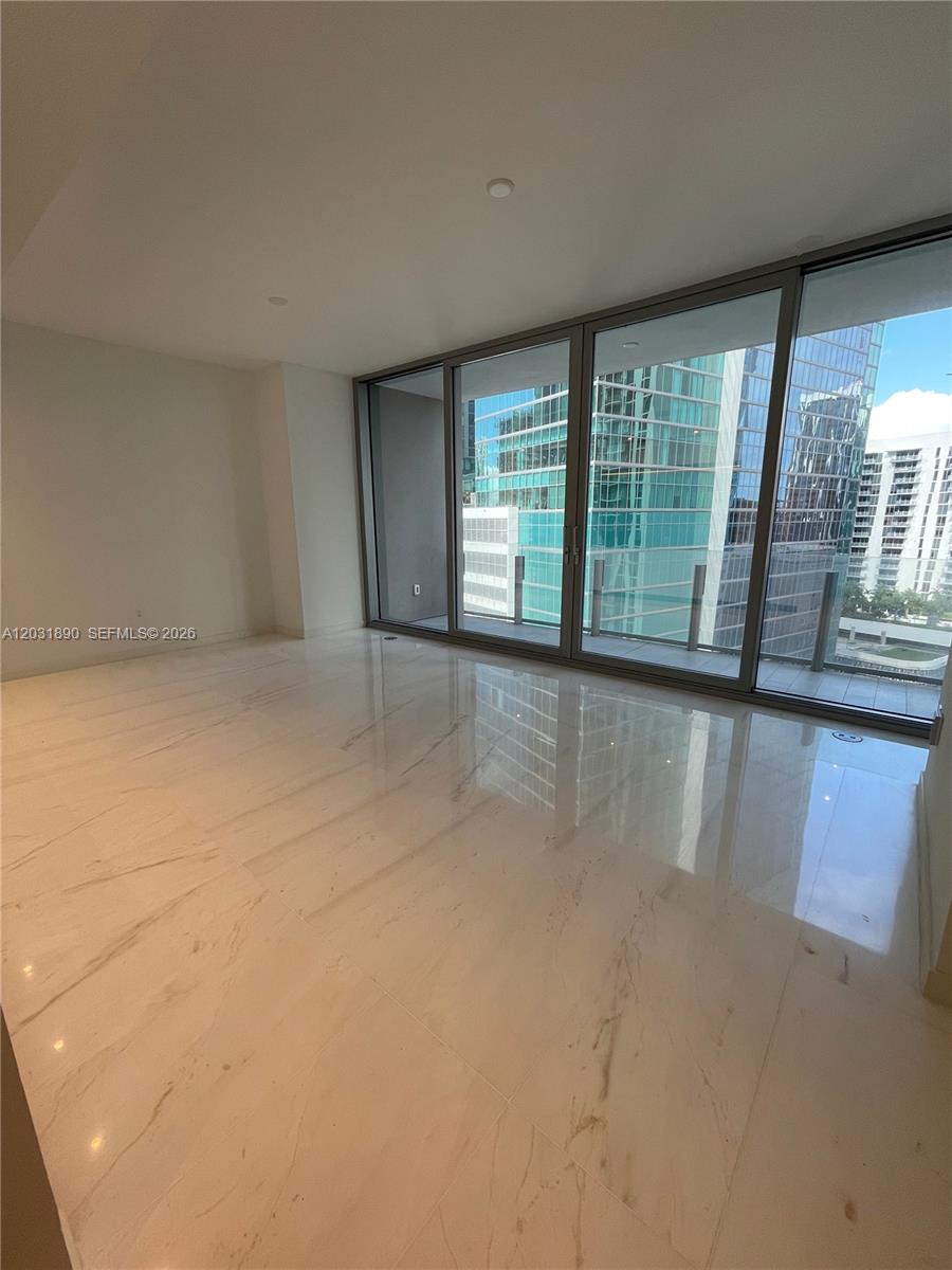 A bright, empty room features white marble flooring and floor-to-ceiling windows overlooking city buildings — 300 Biscayne Blvd Way # 2008, Miami FL 33131, MIAMI, FL
