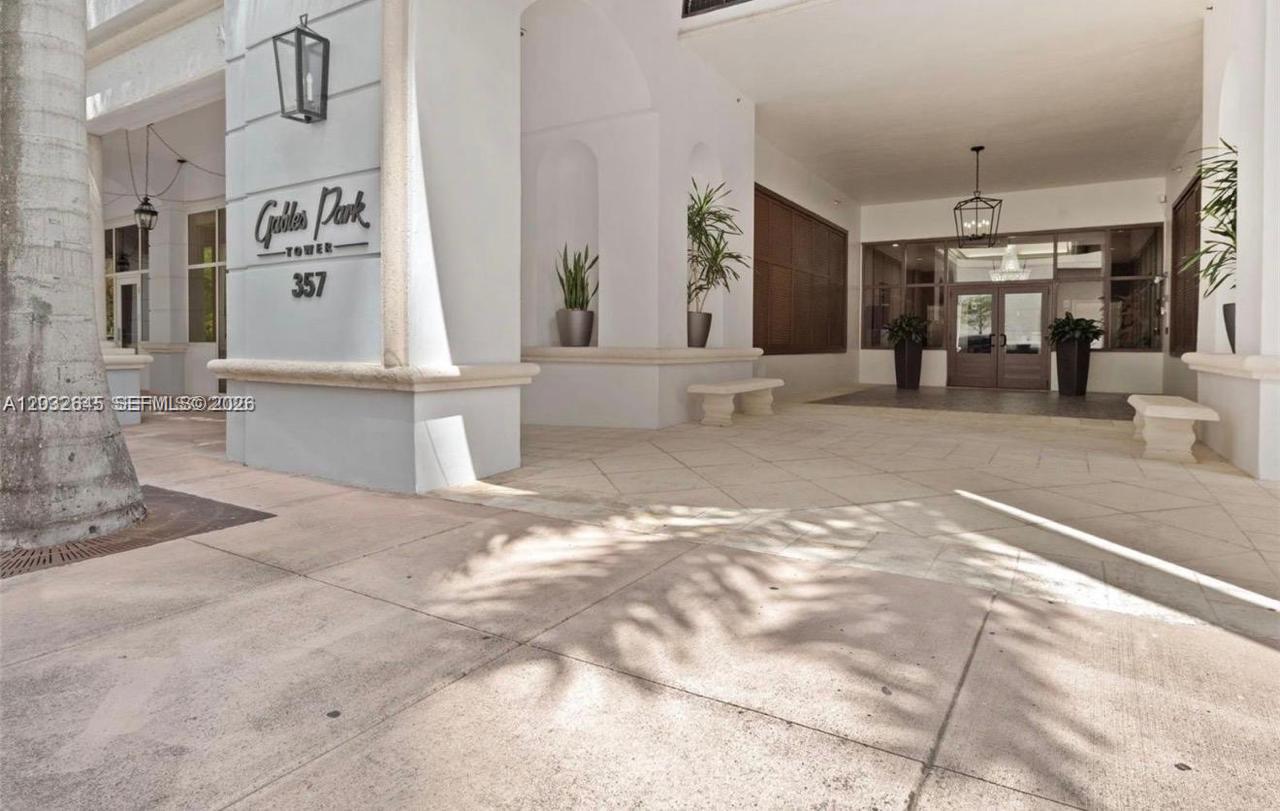 The exterior entrance of a building features a white pillar with signage and benches — 357 Almeria Ave # 802, Coral Gables FL 33134, CORAL GABLES, FL