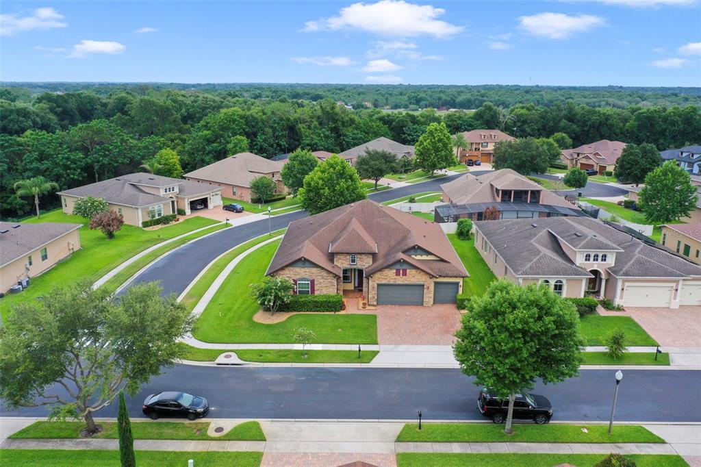 An aerial view shows a suburban house with a brick facade and a brown roof — 1315 ARDEN OAKS DRIVE, OCOEE, FL