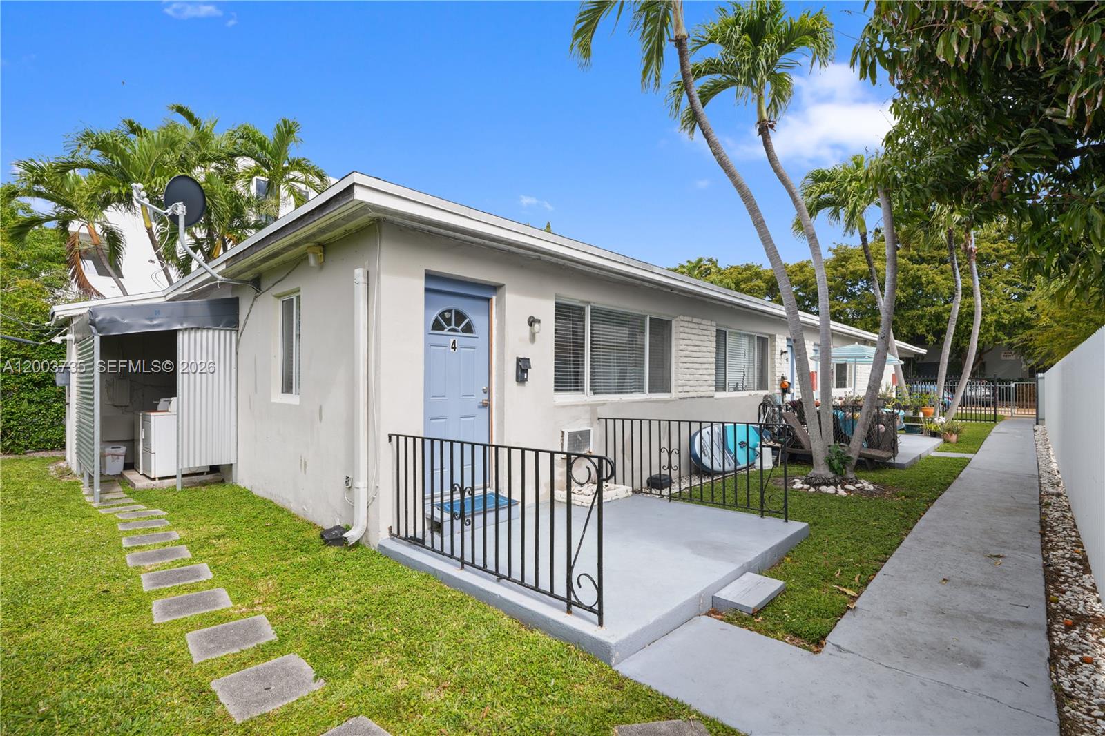 A single-story building with a blue door, a small concrete porch, and a laundry area — 730 84th St, Miami Beach FL 33141, MIAMI BEACH, FL