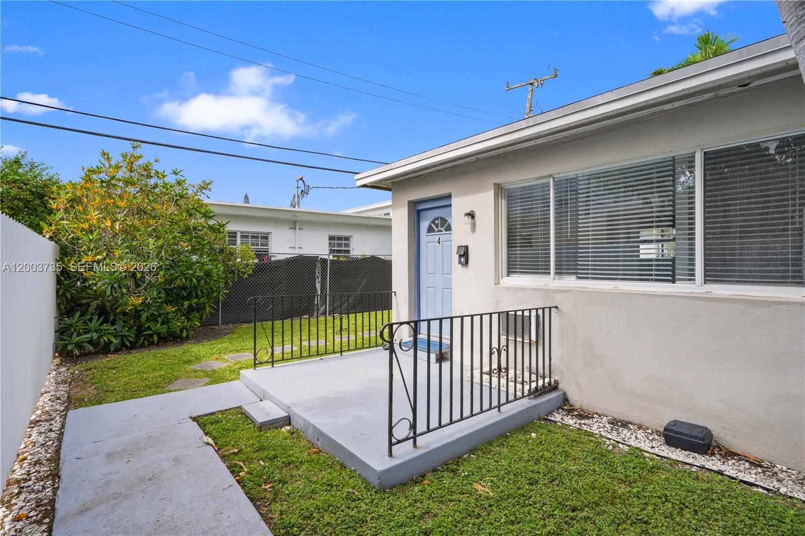 A small concrete patio with a black metal railing sits outside a light-colored building — 730 84th St, Miami Beach FL 33141, MIAMI BEACH, FL