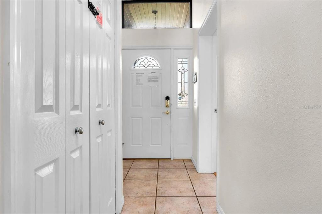 A single-story gray house with a two-car garage and palm trees in the front yard — 714 CARIBOU DRIVE, POINCIANA, FL
