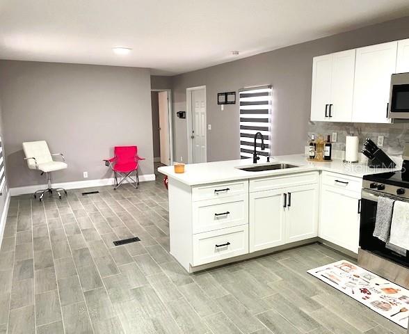 A kitchen with white cabinets, a central island, and gray wood-look tile flooring — 15731 SE 72ND PLACE, MORRISTON, FL