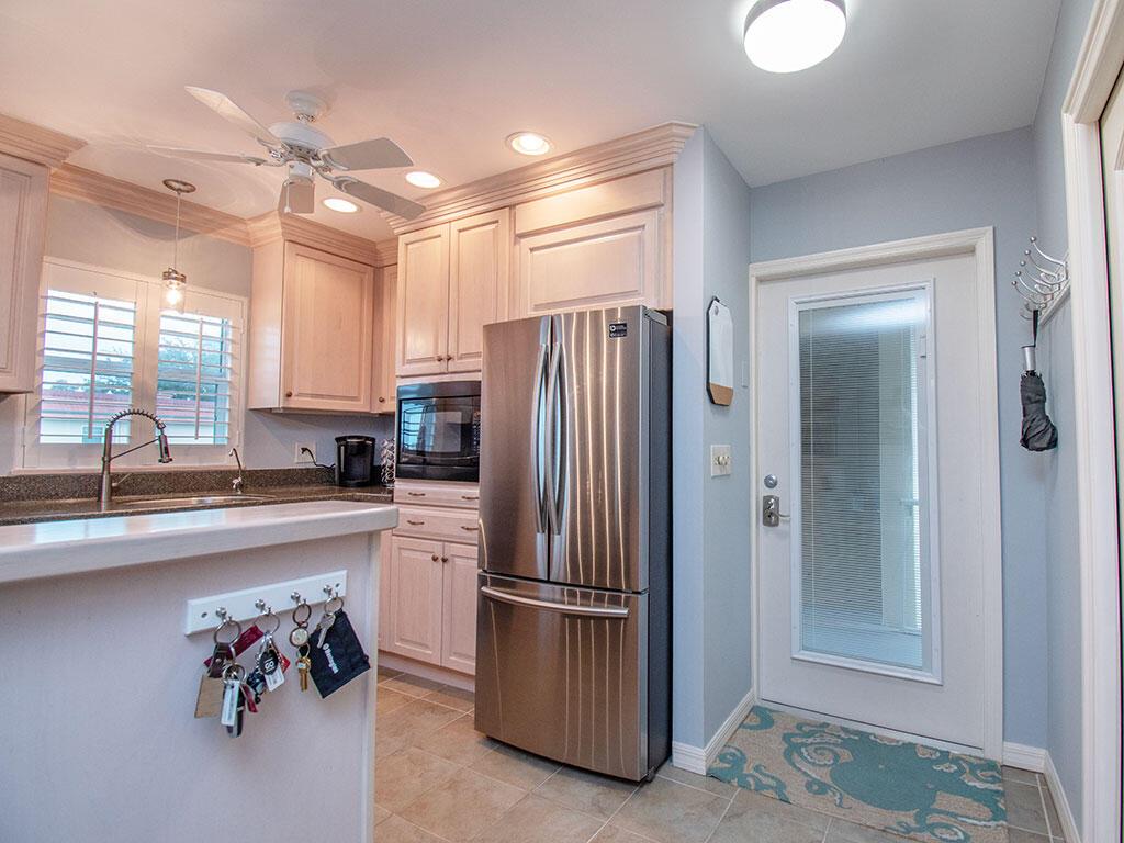 A kitchen features light wood cabinets, stainless steel appliances, and a key rack on the island — VERO BEACH, FL