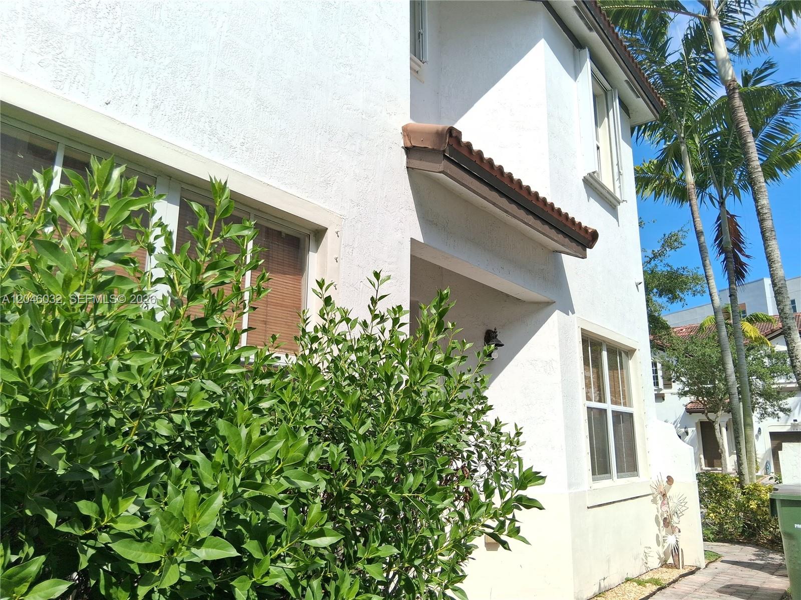 A two-story white stucco building features a tiled awning over the recessed front entrance — 1044 NE 30th Ave, Homestead FL 33033, HOMESTEAD, FL