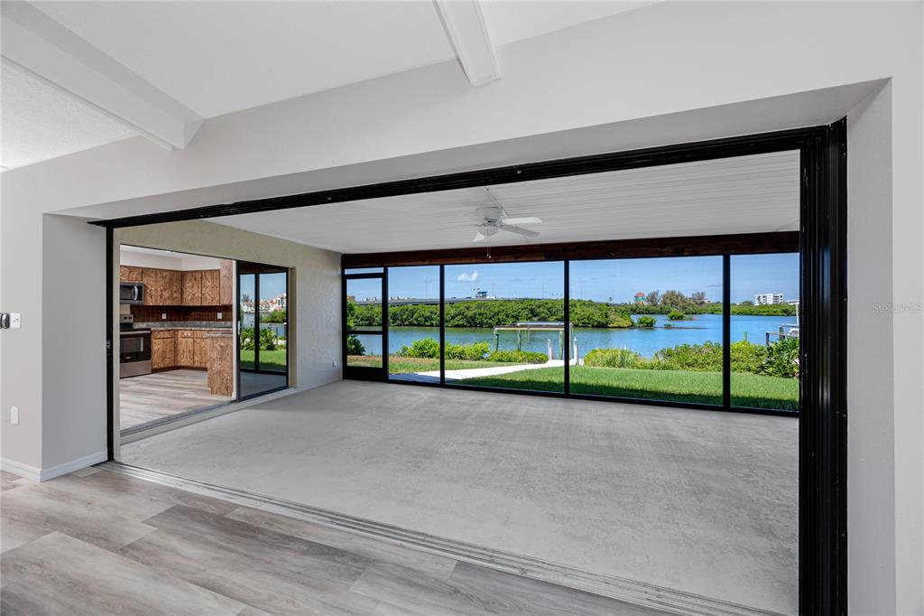 A living area with large sliding glass doors opens to a view of the water — 8046 BAYHAVEN DRIVE, SEMINOLE, FL