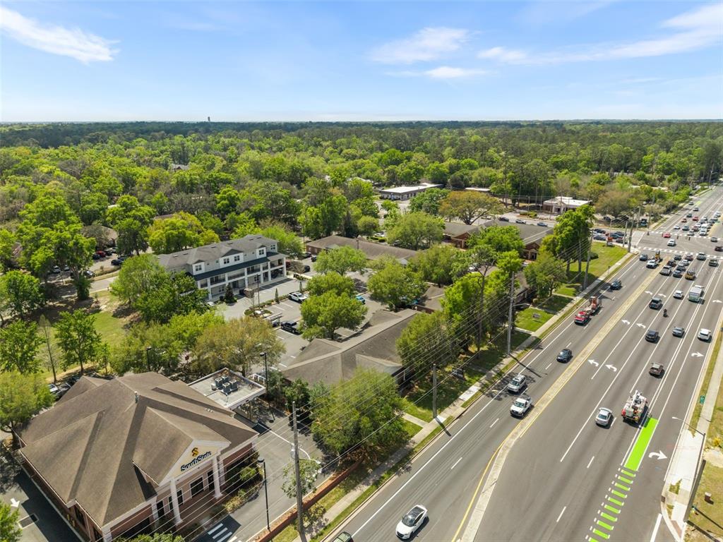A professional office space features a glass-topped conference table, ergonomic chairs, and beige walls — 4110 NW 37TH PLACE UNIT A, GAINESVILLE, FL