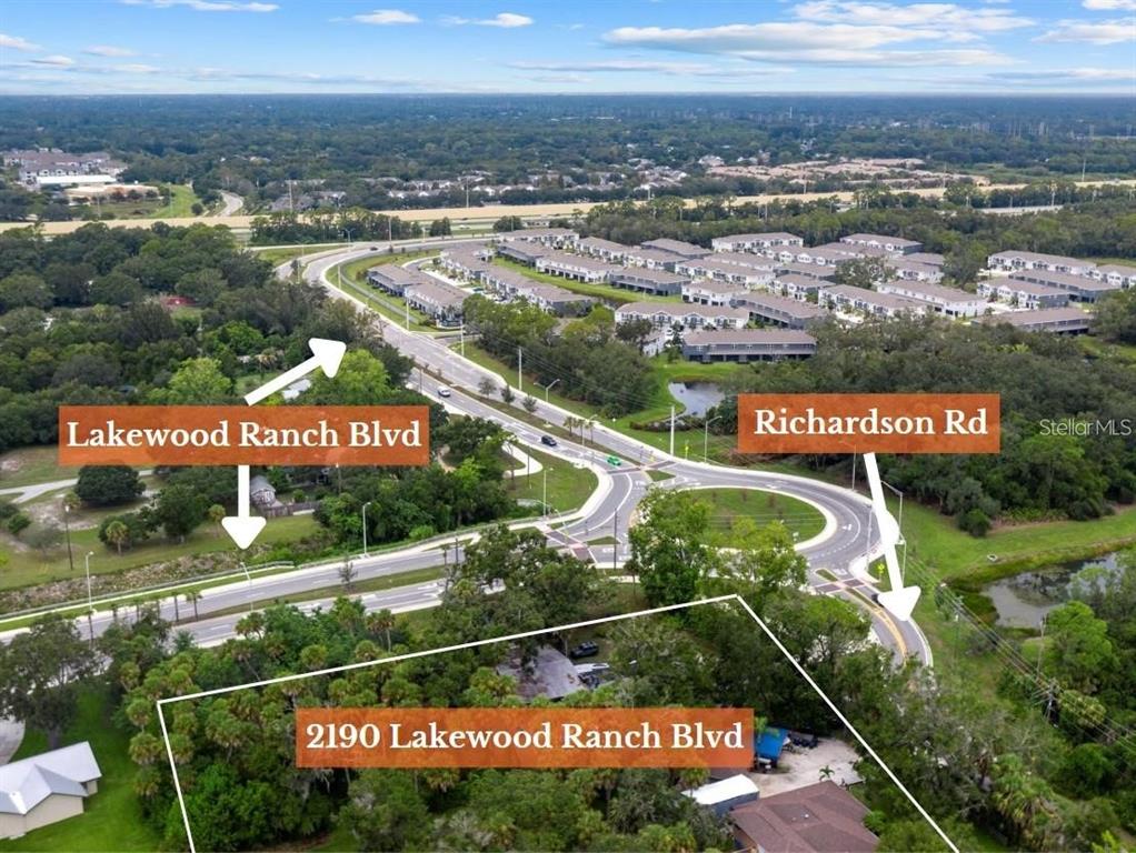 This aerial view shows a wooded property lot located near a road intersection — 2190 LAKEWOOD RANCH BOULEVARD, SARASOTA, FL