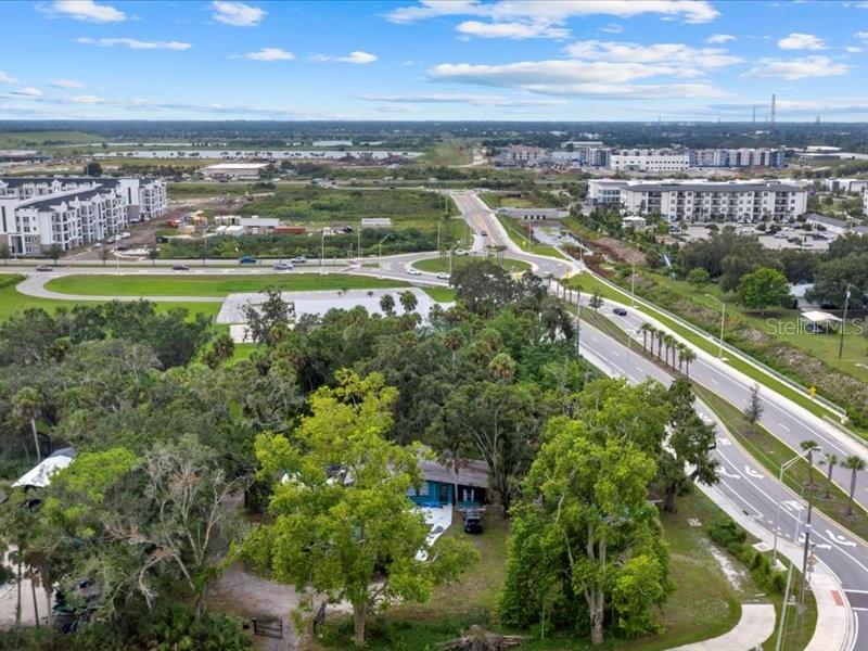 An aerial view shows a house nestled among trees near a road and a roundabout — 2190 LAKEWOOD RANCH BOULEVARD, SARASOTA, FL