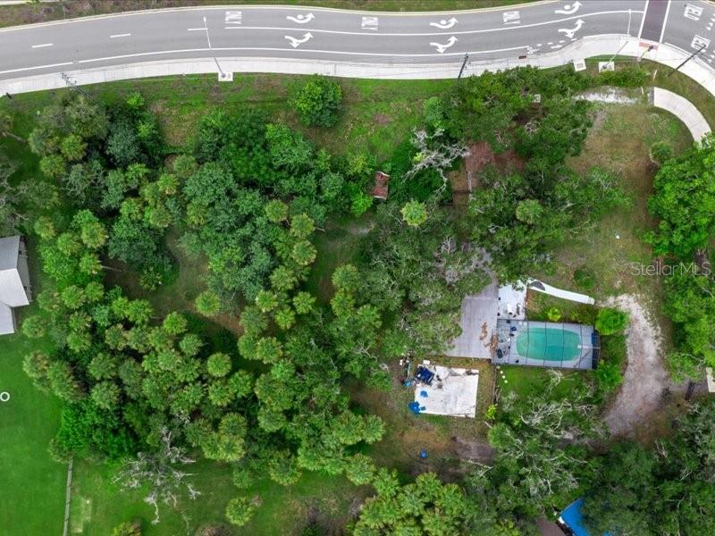 An aerial view shows a wooded lot with a house, pool, and adjacent road — 2190 LAKEWOOD RANCH BOULEVARD, SARASOTA, FL