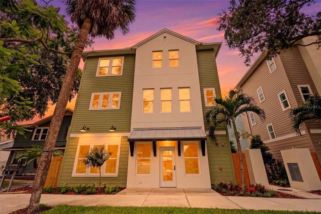 A three-story house with green siding and a white central facade at sunset — 2540 1ST AVENUE N, ST PETERSBURG, FL