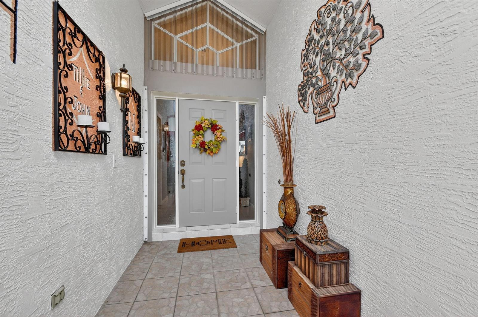 A front entryway features a gray door, tiled flooring, and decorative wall art — 2249 Soundings Court, FL 33413, FL