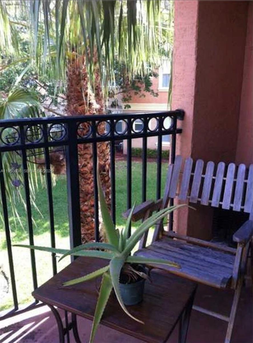 A potted aloe plant sits on a small table on a balcony with a wooden chair — 4600 SW 160th Ave # 620, Miramar FL 33027, MIRAMAR, FL
